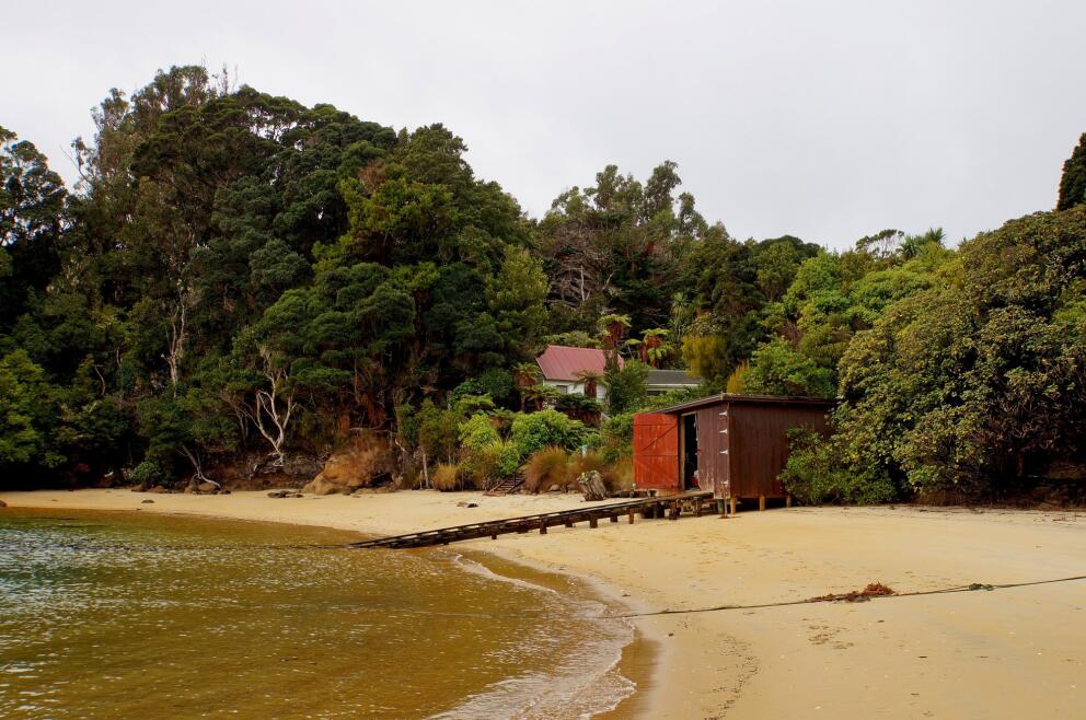 Small beachfront building beside a sheltered New Zealand beach