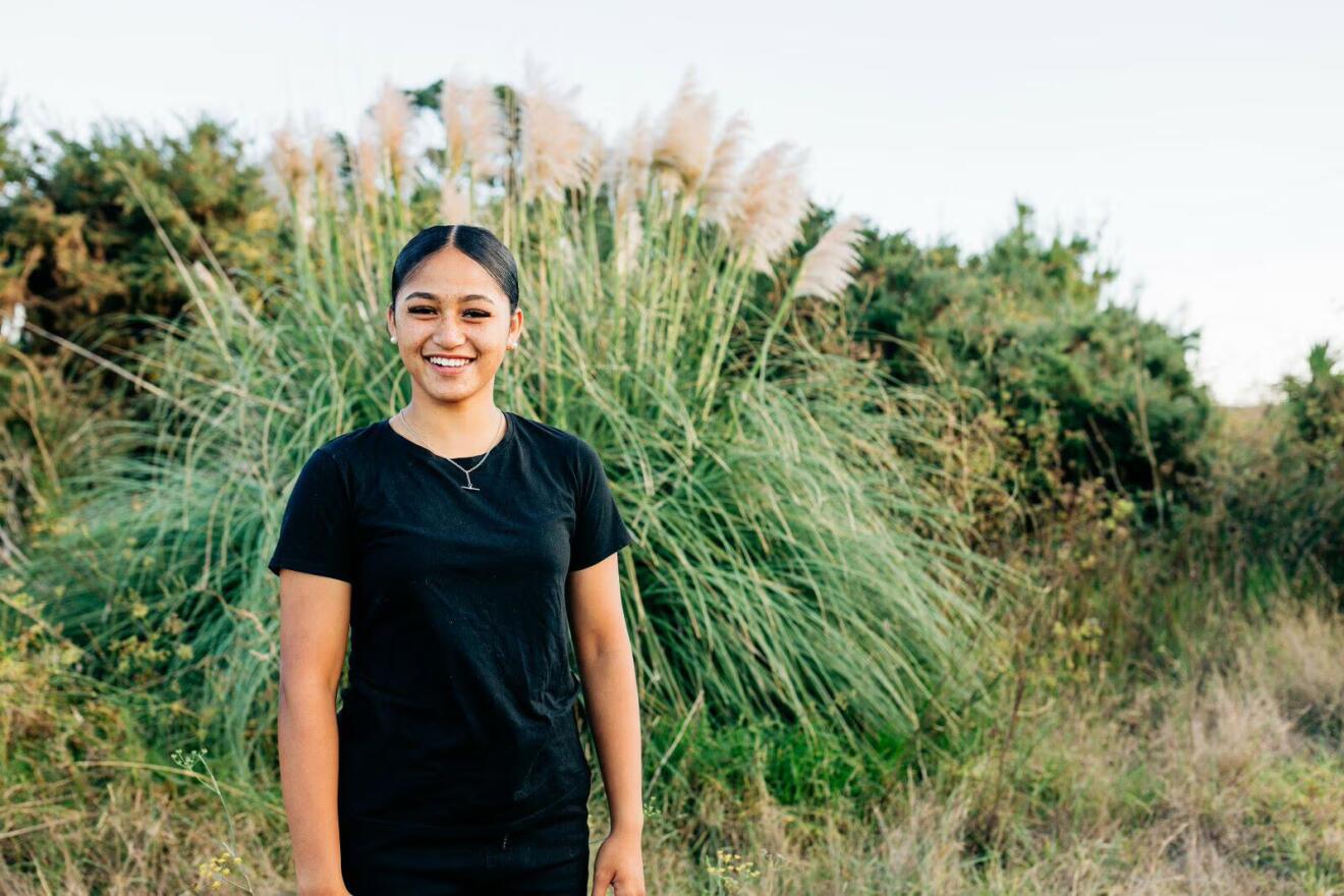 Young person standing in front of toetoe